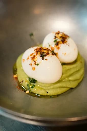 Six-minute eggs with chili flakes on avocado mousse